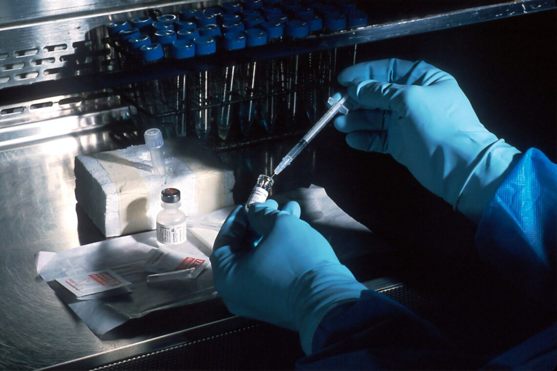 Des mains avec des gants qui préparent les échantillons pour un test adn dans un laboratoire
