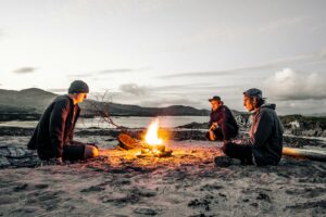 trois hommes devant un feu de joie